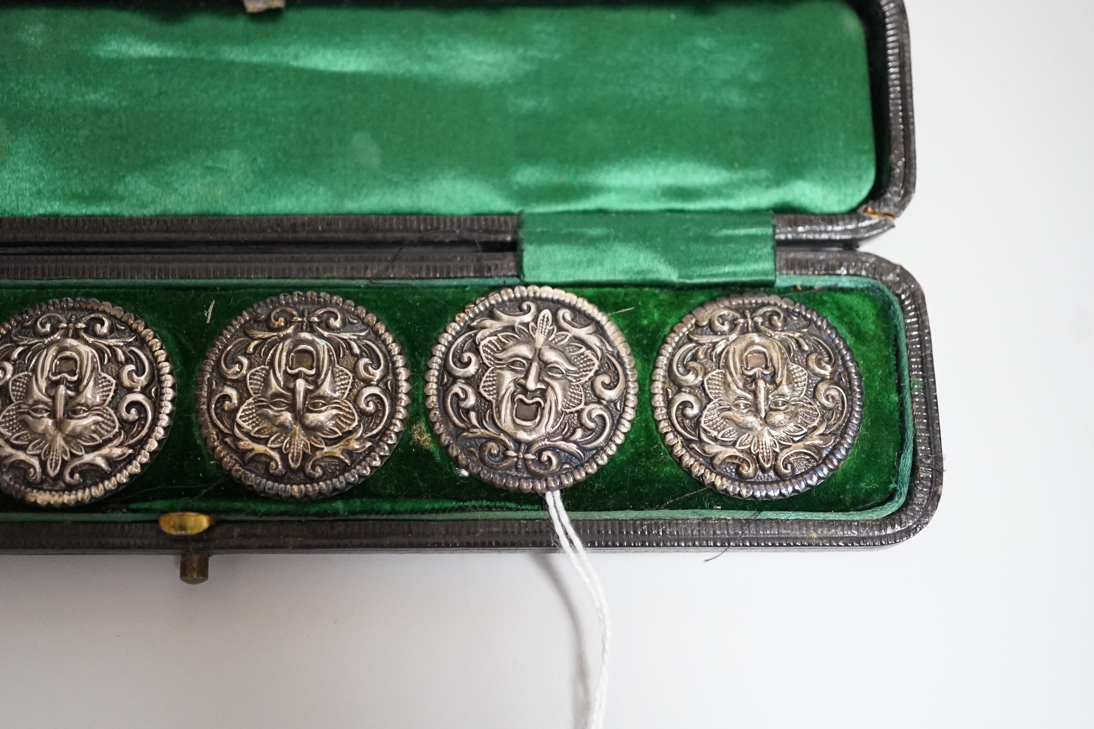 A cased set of six Edwardian silver buttons, each embossed with a mask, Henry Matthews, Birmingham, 1902, 27mm.